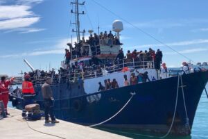 Catania, 700 migranti arrivano al molo di Levante al grido di “bella Italia”: su un barcone scortato dalla Guardia costiera